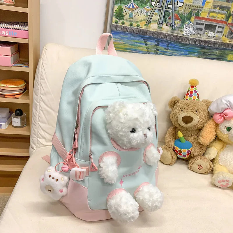 Macaron colour nylon school backpack with curved straps, shown in yellow pink, with a pendant attached.