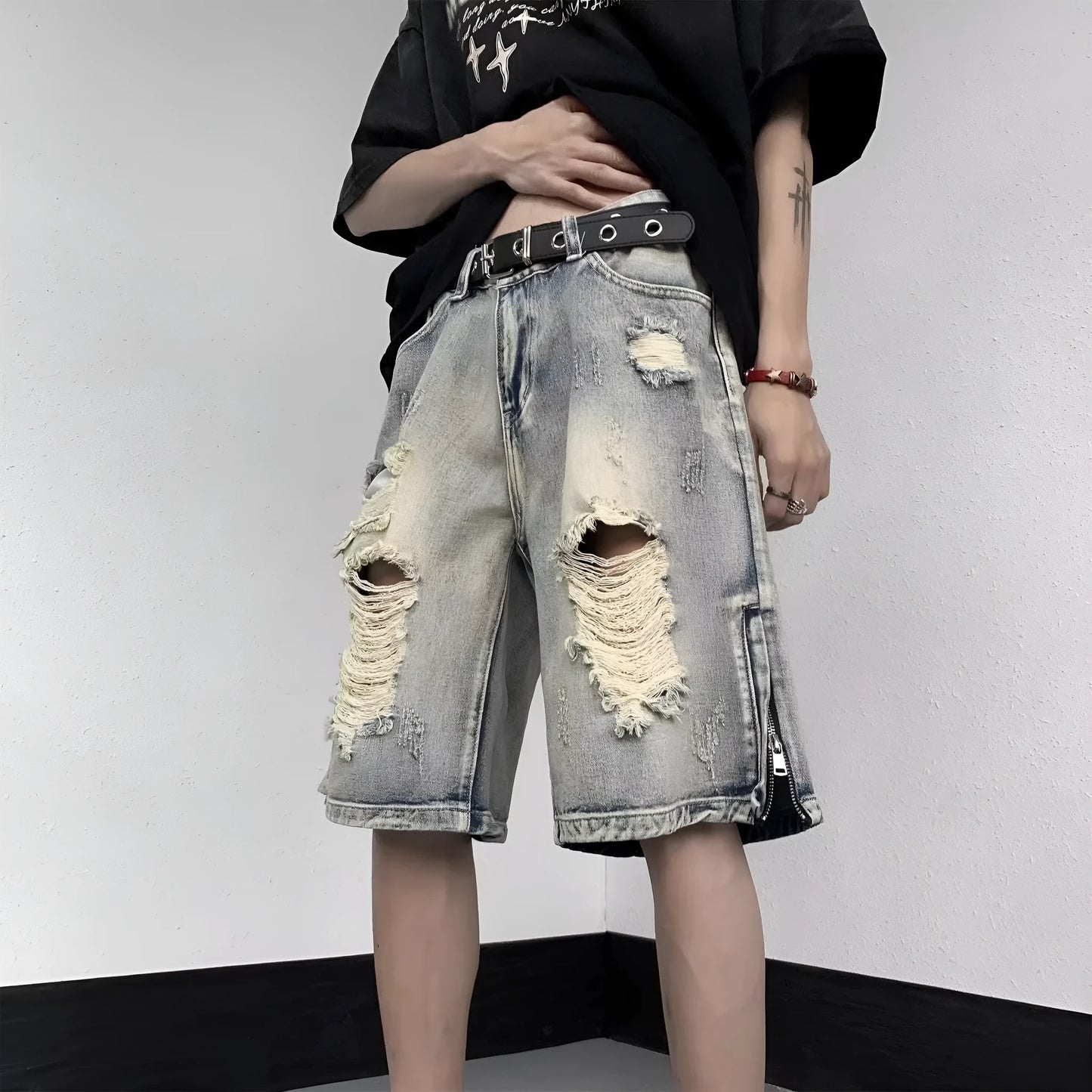A pair of faded blue denim shorts with a tattered, distressed finish and a loose wide-leg silhouette.