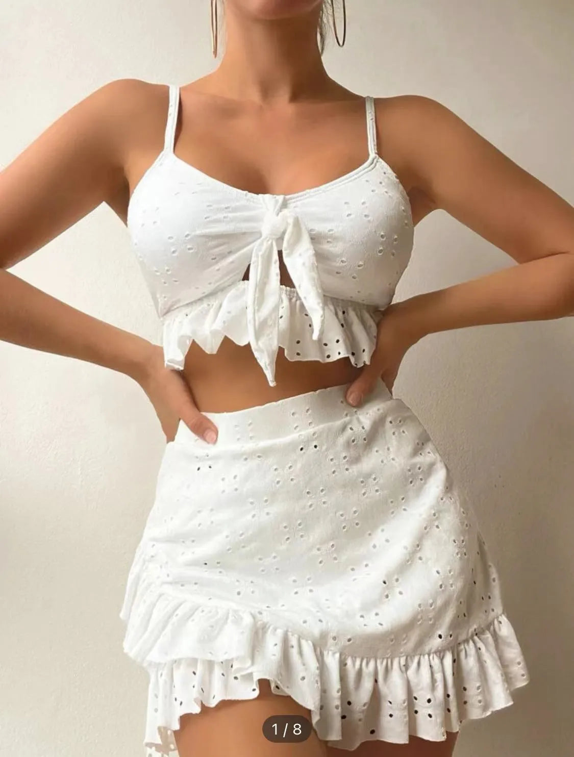 Women's solid colour three-piece bikini swimsuit with a split hip skirt.