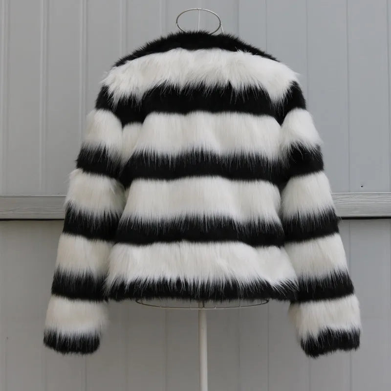 Womens black and white striped long-sleeved faux fur leather jacket on a hanger.