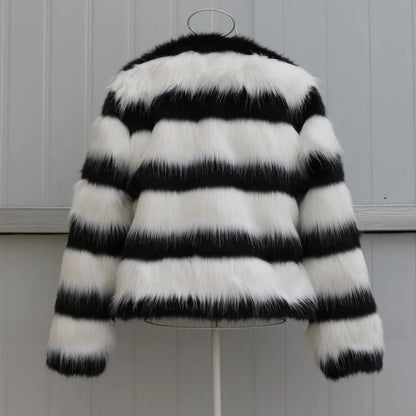 Womens black and white striped long-sleeved faux fur leather jacket on a hanger.