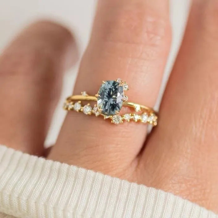 Gold-plated floral women's ring with a green zircon stone centrepiece on a model's hand.