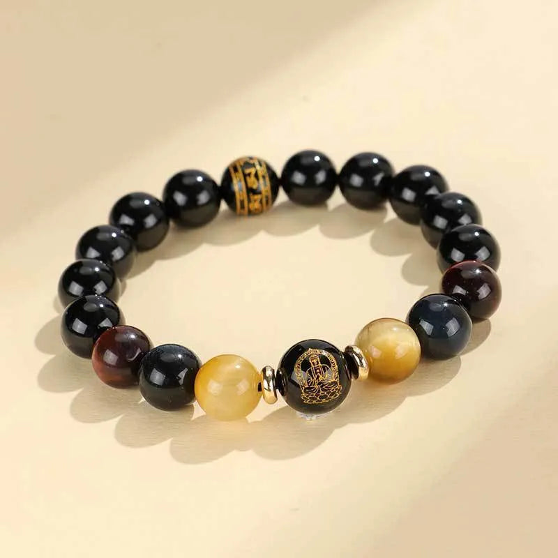 Handcrafted black agate and tiger eye stone beaded bracelet with a central carved zodiac deity charm.