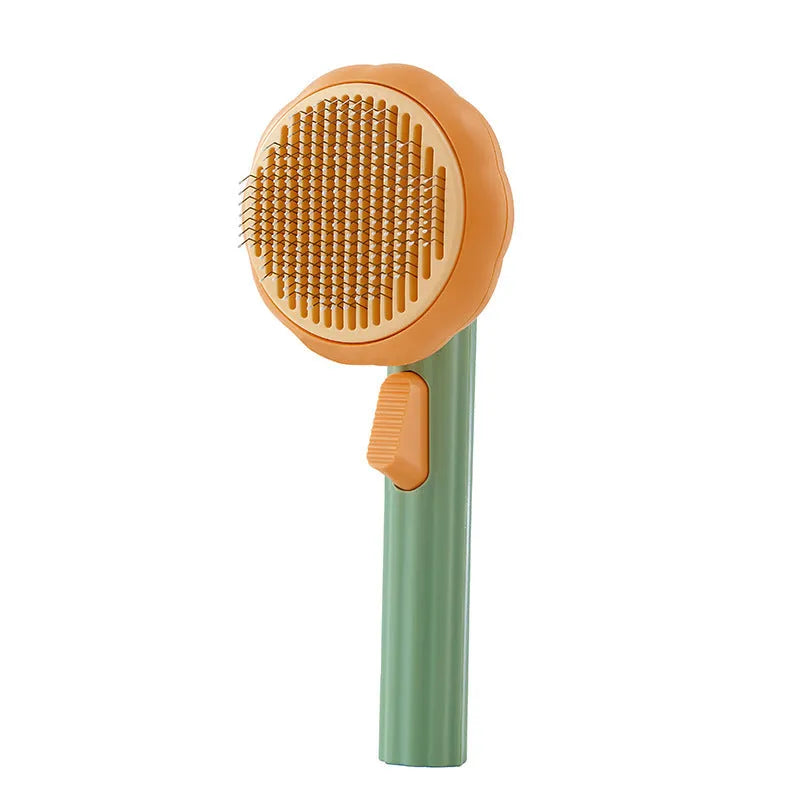 Hand-held pumpkin-coloured pet brush with stainless steel needles for grooming cats and dogs
