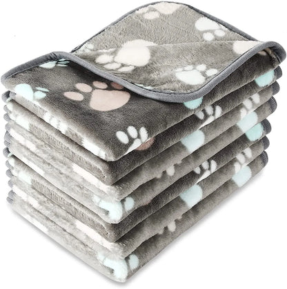 Coral fleece dog blanket with paw print pattern, shown in beige colour, laid flat to show size and soft texture.