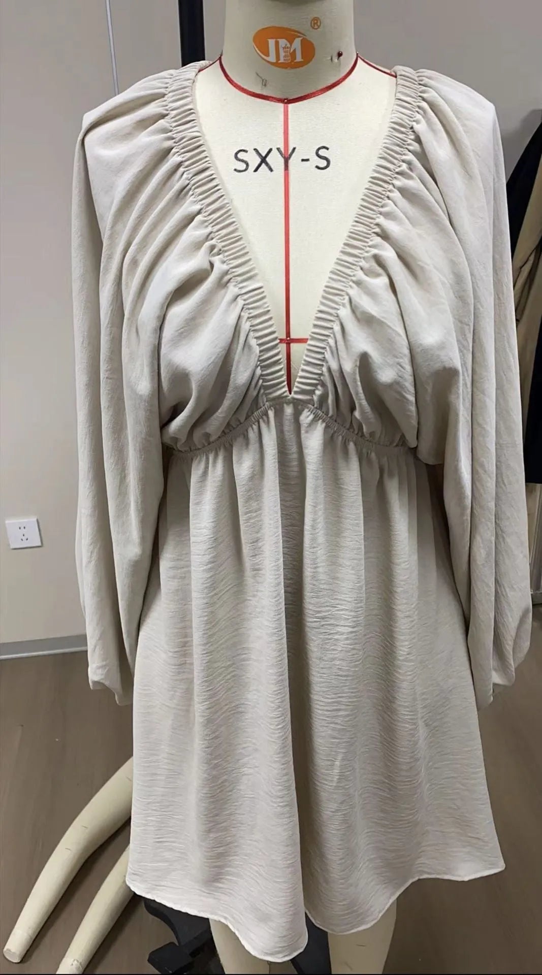 Women's apricot V-neck dress with long puff sleeves and a flounced swing skirt.