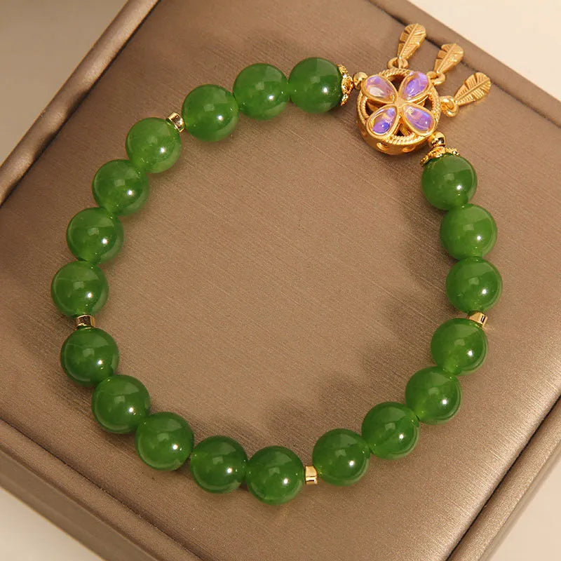 Green jasper crystal four-leaf clover dream catcher pendant on a women's bracelet.