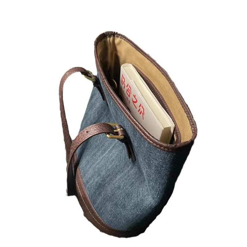 Large blue denim patchwork bucket handbag with one shoulder strap.