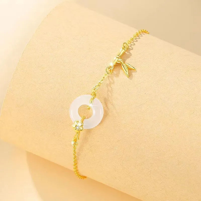 Women's silver and gold electroplated bracelet with peace buckle charm and white chalcedony stone.