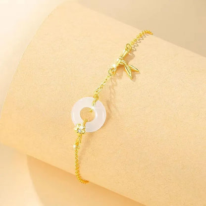 Women's silver and gold electroplated bracelet with peace buckle charm and white chalcedony stone.