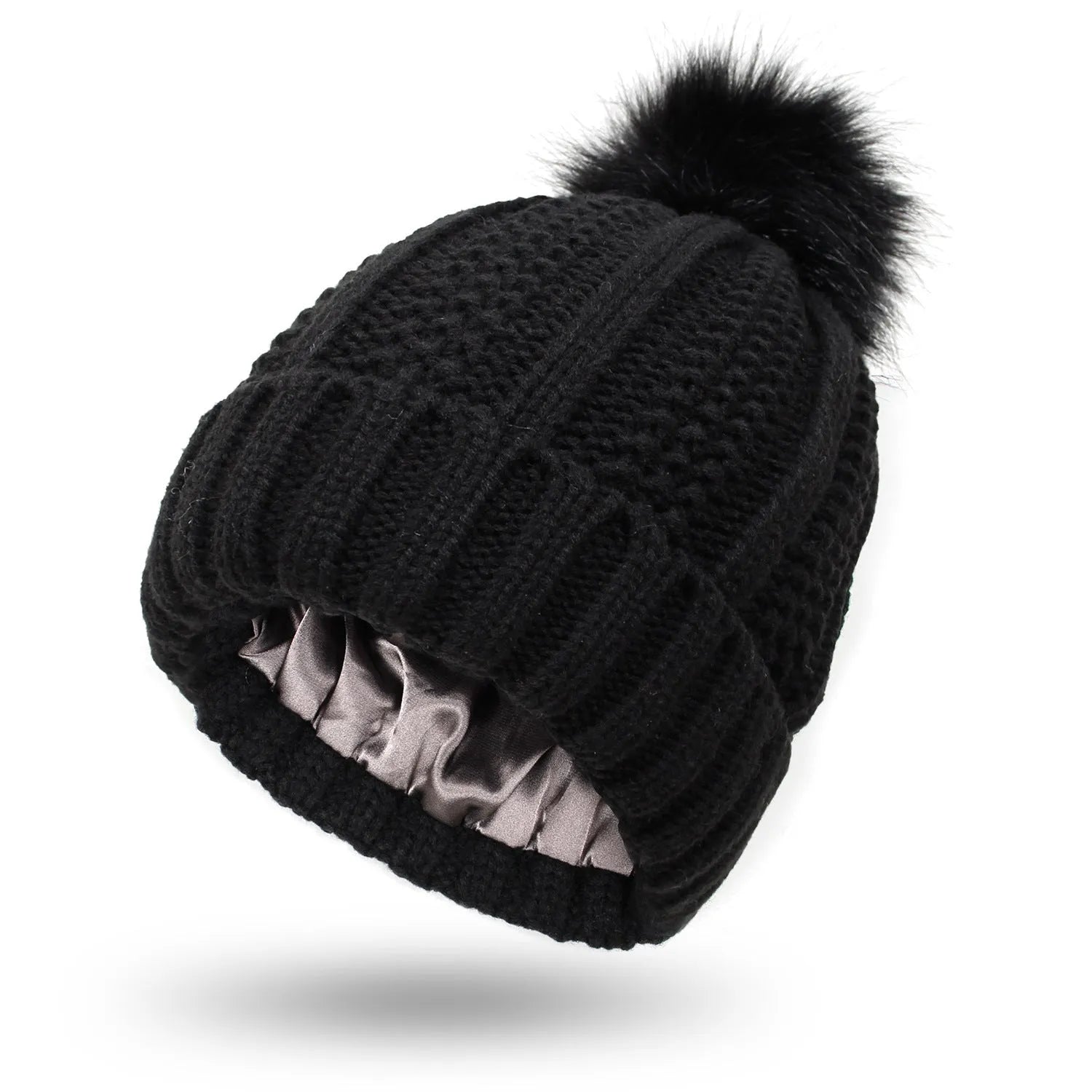 Woman wearing a wine red wool beanie hat with a faux fur pom pom and satin lining.