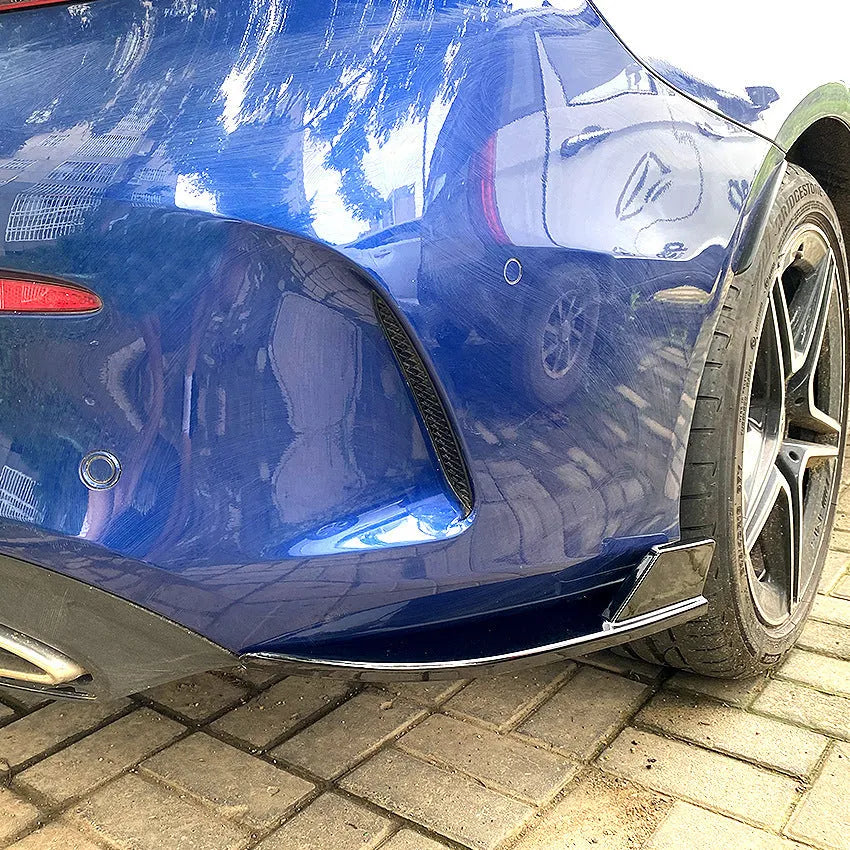 Car rear corner protectors in PP plastic, shown in piano black and carbon fibre pattern finishes