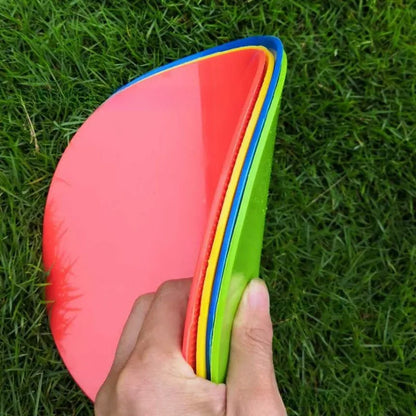 Soft yellow TPE football training landmark pad disc on grass, 23cm diameter.