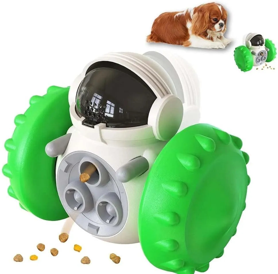 A black, robot-shaped treat dispenser toy for dogs and cats on a wooden floor, showing its size and rolling design.