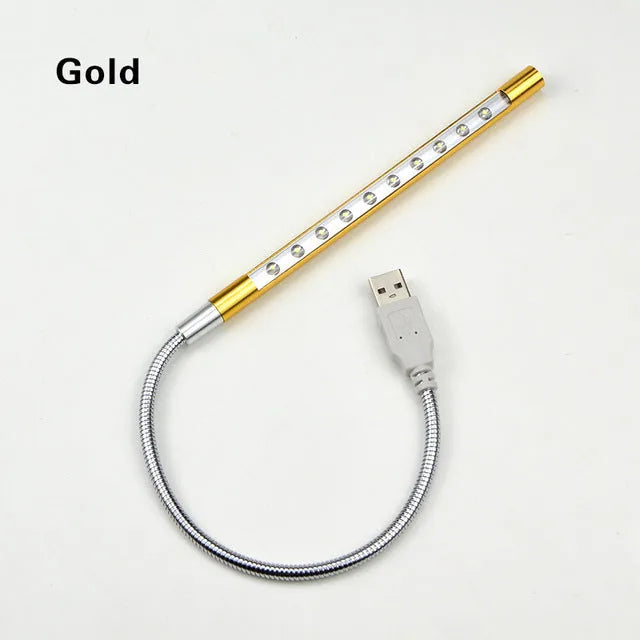 Spiral shaped silver aluminium USB LED desk lamp bent on a wooden desk.