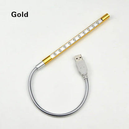 Spiral shaped silver aluminium USB LED desk lamp bent on a wooden desk.