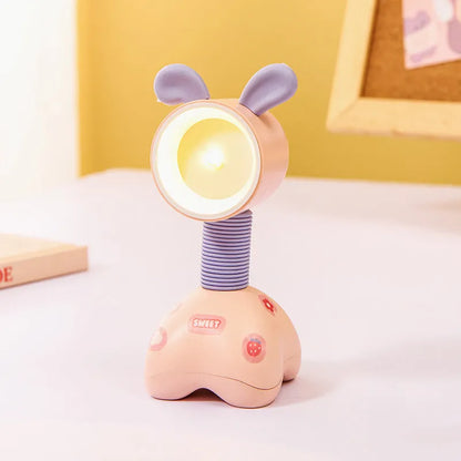 Colourful cartoon character magnetic DIY night light on a desk with adjustable head.