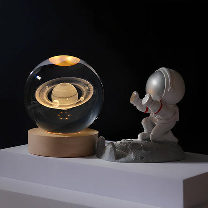 Cosmos Series crystal ball night light with wooden base and astronaut figure, showing Milky Way light pattern