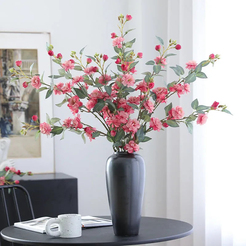 Artificial silk camellia flower in a vase, colours include white, pink, rose pink, and orange coffee.