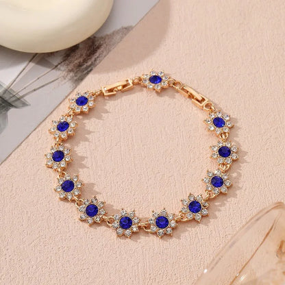 Gold and silver electroplated bracelets with flower charms set with coloured gemstones.