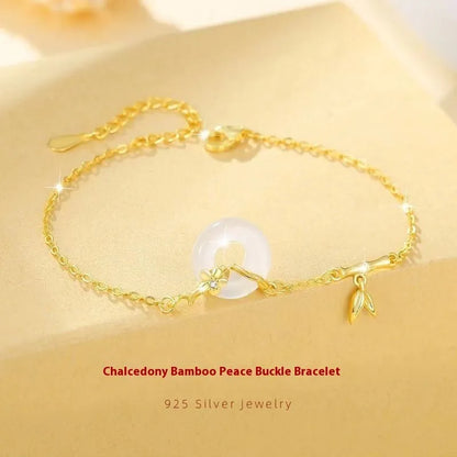 Women's silver and gold electroplated bracelet with peace buckle charm and white chalcedony stone.