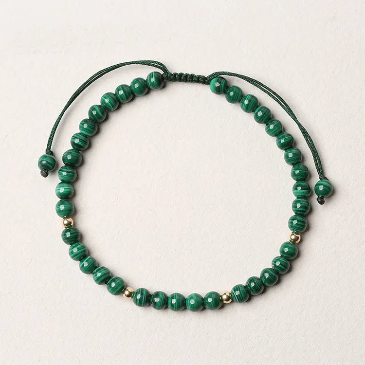Handwoven green malachite crystal bracelet for women with golden ball accents.