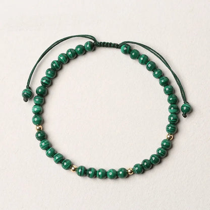 Handwoven green malachite crystal bracelet for women with golden ball accents.