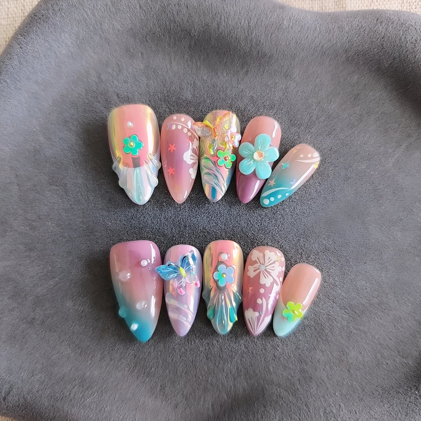 Handmade nail art sculpture set with embossed flower and butterfly designs in four sizes for almond-shaped nails