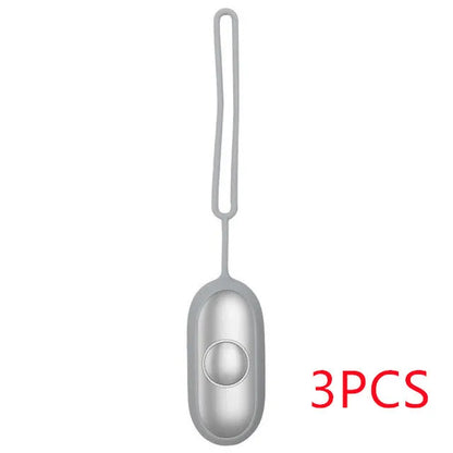 Hand-held micro-current sleep aid device in grey, green, or orange with round button and USB charging port