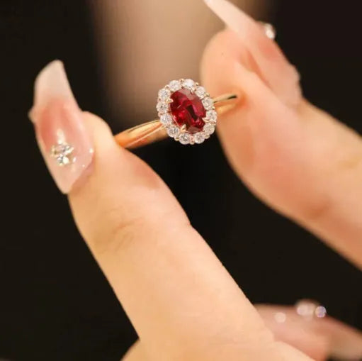 Gold pigeon and floral design women's ring with red gemstone inlay on a silver band.