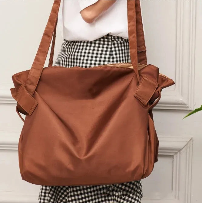 Women's black waterproof Oxford cloth crossbody shoulder bag with expansion function.
