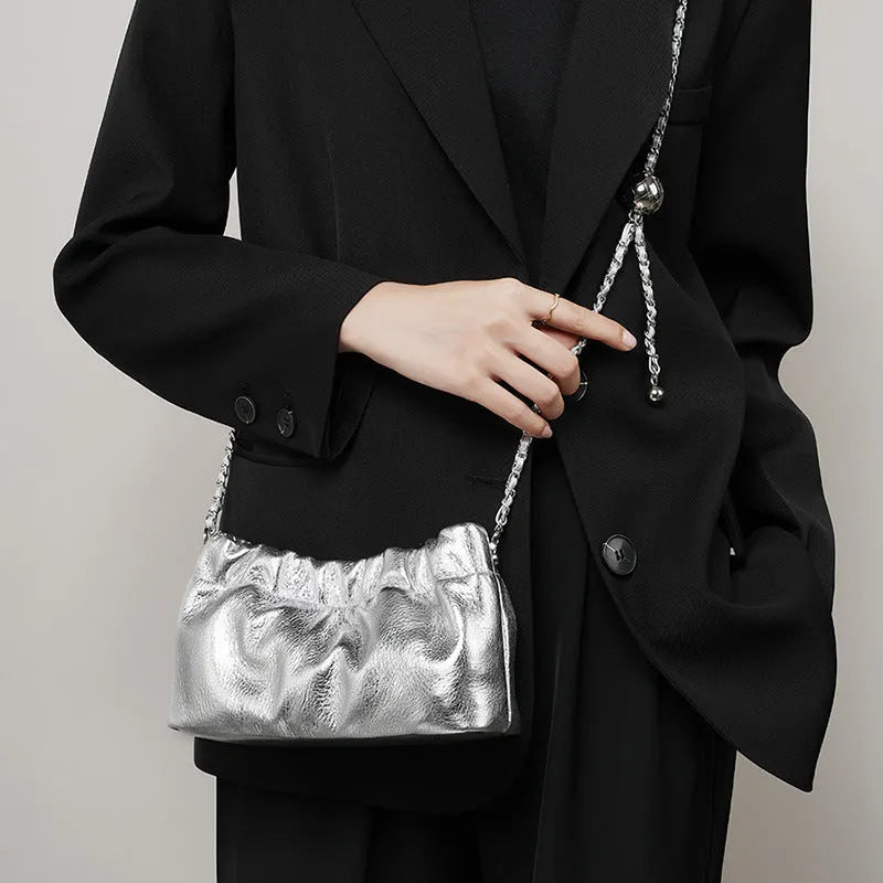 Women's dumpling-shaped genuine leather crossbody bag in three neutral colours showing slit pocket