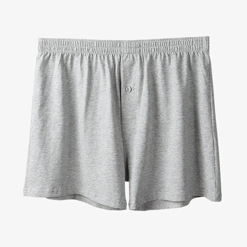 Men's light grey cotton boxer shorts with a loose fit and high waist on a plain background.