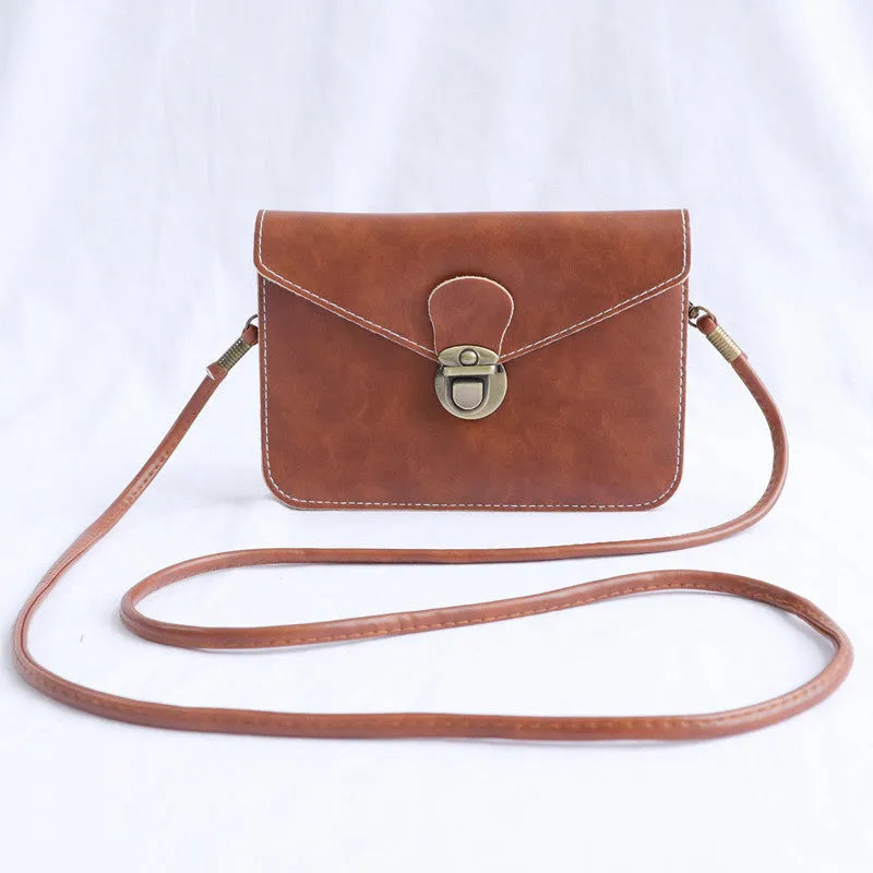 Retro shoulder messenger bag in cross square shape with flap and lock closure, showing internal mobile phone compartment