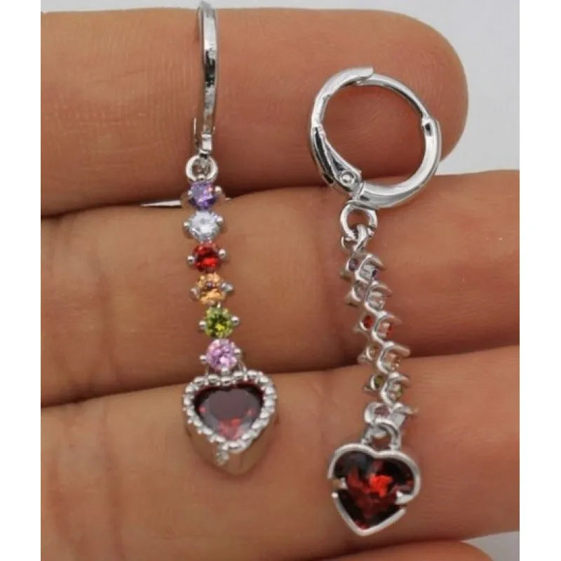 A pair of small gold-coloured heart-shaped alloy earrings on a plain background.