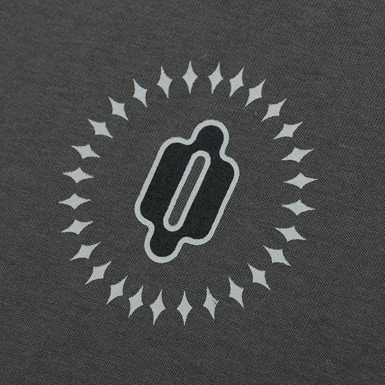 Woman wearing a grey khaki loose drop shoulder sweatshirt with a printed letter design.
