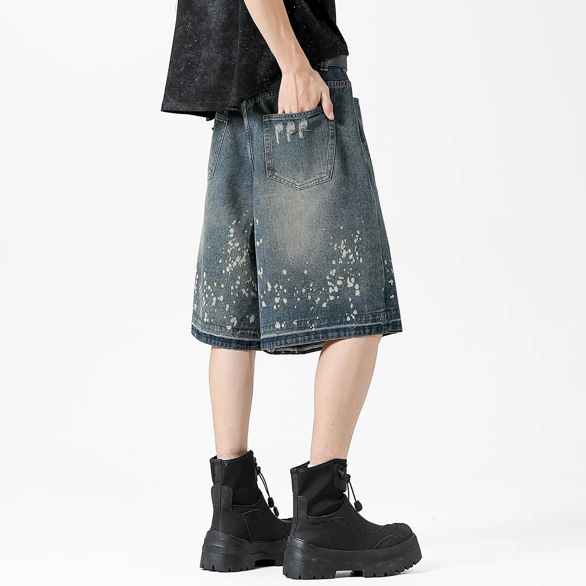 Men's retro blue denim shorts with ripped knees and splash ink detailing, straight leg mid-thigh cut.