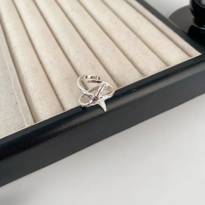 Three-dimensional floral jasmine ring with open-mouth adjustable design on a plain background.