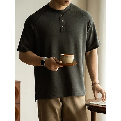 Women's loose grey terry texture casual pullover top with raglan sleeves on a hanger.