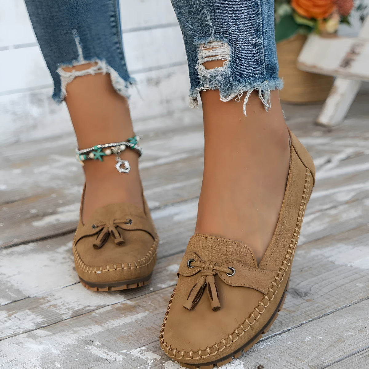 Women's solid-colour suede flat shoes with a bow on the front, shown in apricot colour.