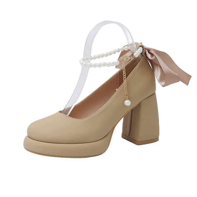 Women's beige preppy style Mary Jane shoes with chunky heel, ankle strap buckle, and pearl detail.