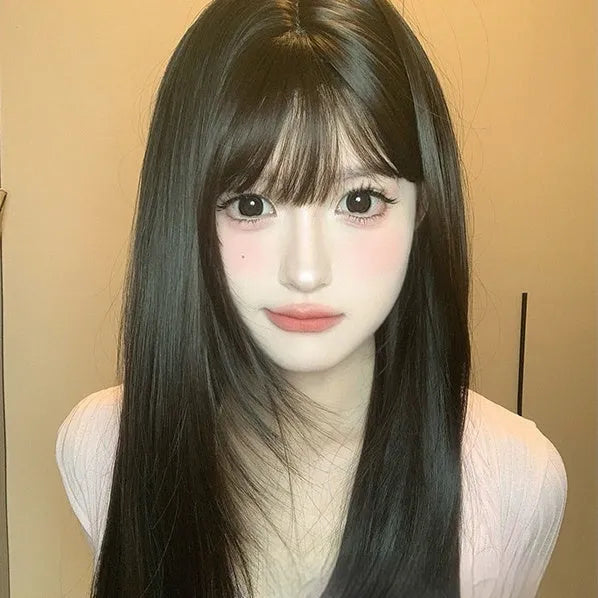 Dark brown long straight synthetic wig with fringe on a wig stand.