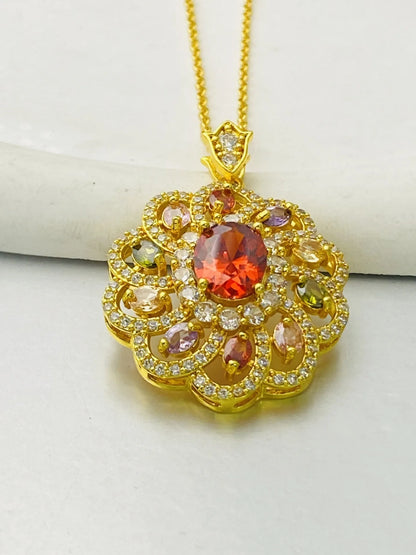 Close-up of a women's flower-shaped pendant necklace with a colourful zircon stone in a choice of gold, champagne gold, or platinum colour finishes.