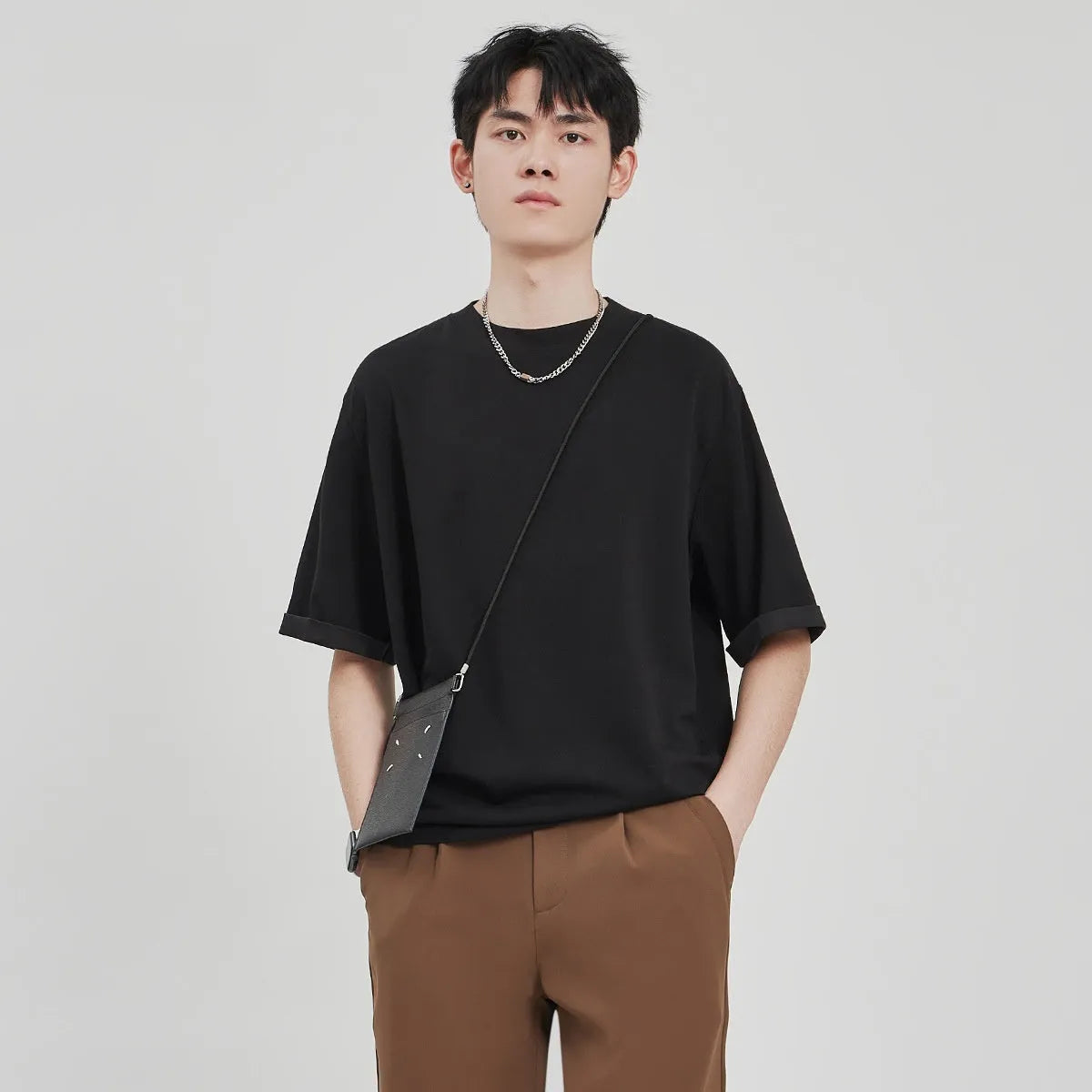 Men's brown drape knit loose t-shirt with short sleeves on a hanger.