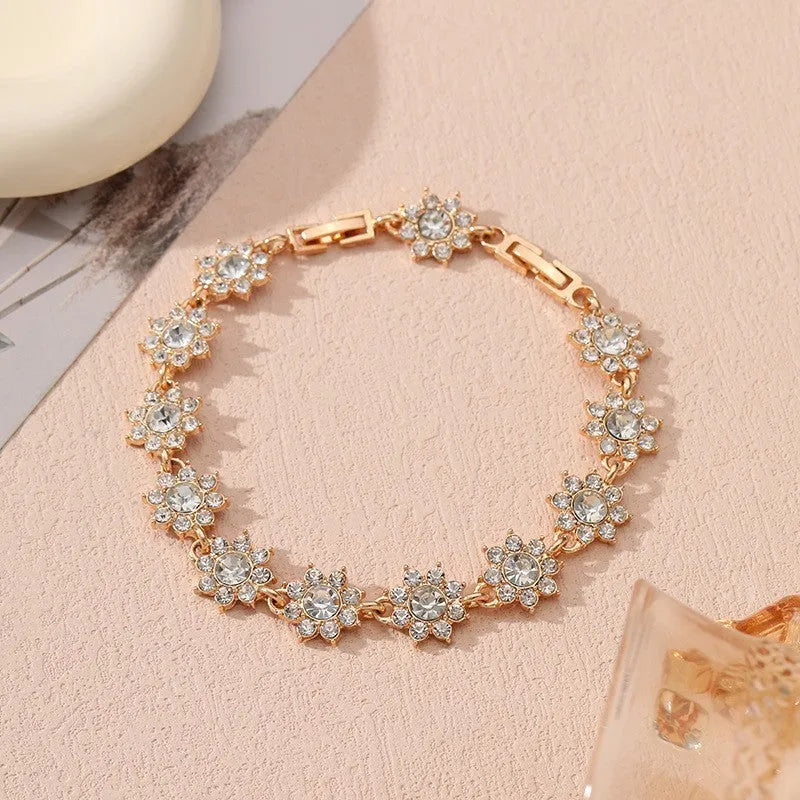 Gold and silver electroplated bracelets with flower charms set with coloured gemstones.