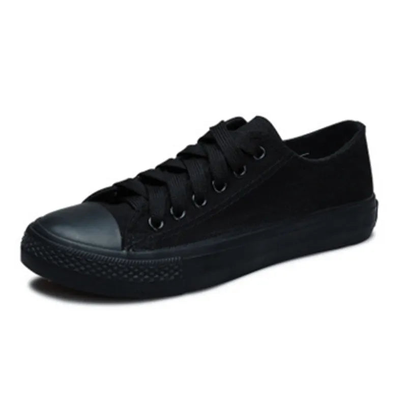 Women's solid-colour canvas casual shoes in black, shown from the side.
