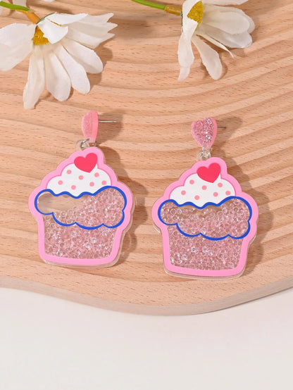 A pair of colourful acrylic earrings shaped like a strawberry and a cherry on a woman's ear.