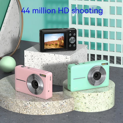 Colourful children's mini digital camera with large screen, showing black, pink and green options with lanyard.