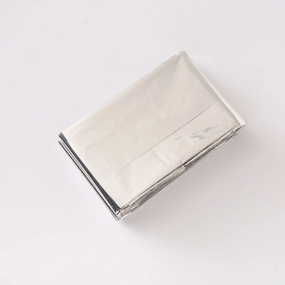 Portable double-sided silver emergency thermal blanket for outdoor adventures and survival situations