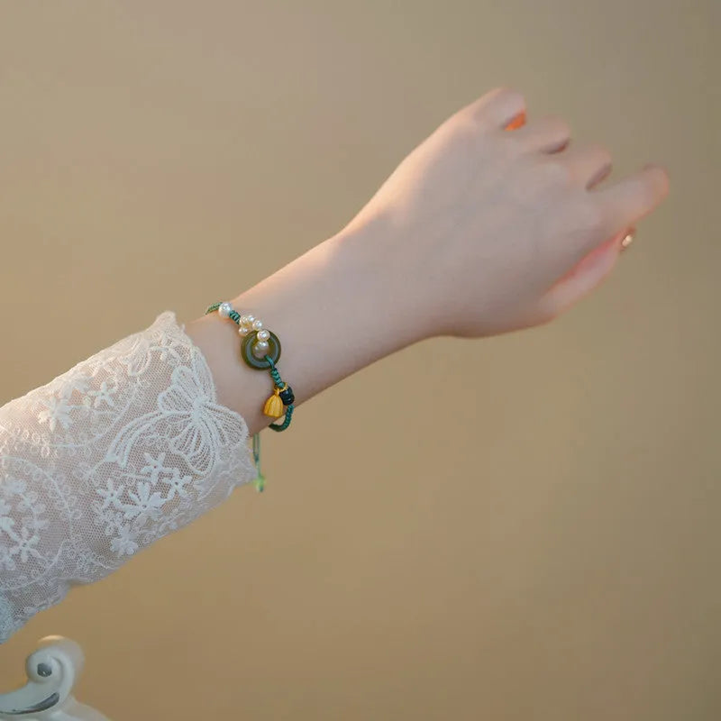 DIY hand-woven watch band with a Pearl Peace Buckle and pearl decoration on a white background.